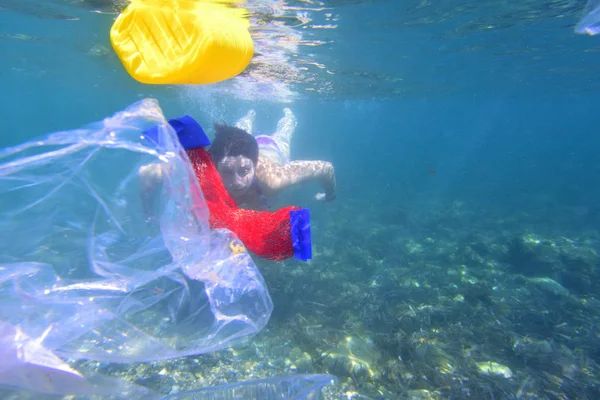 Woman diving in the sea with garbage, plastic — Stock Photo, Image