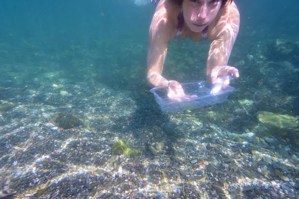 Mujer recogiendo basura, plástico, del fondo del mar —  Fotos de Stock