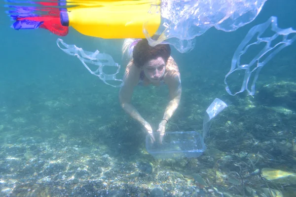 Mujer buceando en el mar con basura, plástico —  Fotos de Stock