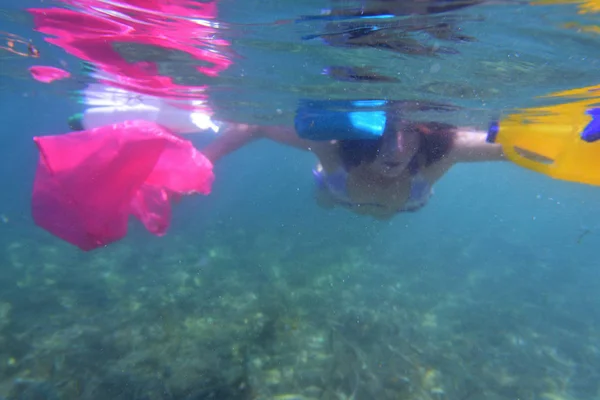 Femme nageant dans la mer avec du plastique dans l'eau — Photo