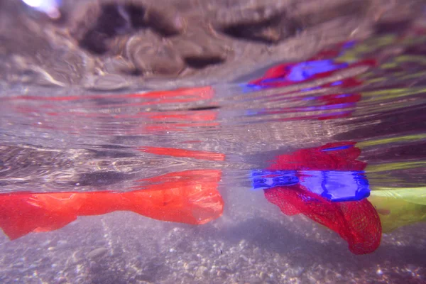 Gekleurde kunststoffen op een strand — Stockfoto