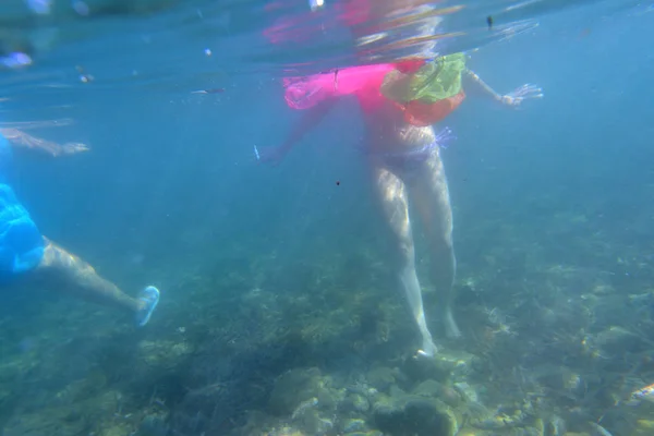 Vrouw zwemmen in de zee met plastic in het water — Stockfoto