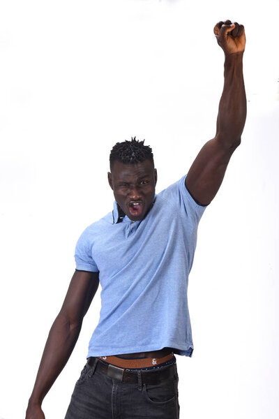 African man raising her arms and smiling in victory sign on white background