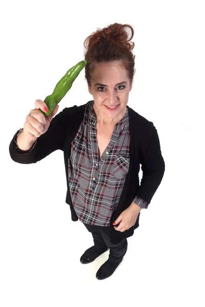 Retrato de uma mulher com pimenta verde no fundo branco — Fotografia de Stock
