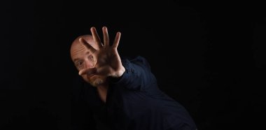 Siyah fırında dur tabelasına uzanmış bir adamın siyah portresi.