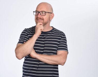 Gözlüklü ve beyaz arka planda bakan bir adamın portresi.