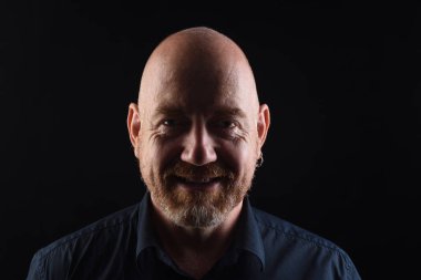 Dişleriyle gülümseyen siyah bir adamın portresi.