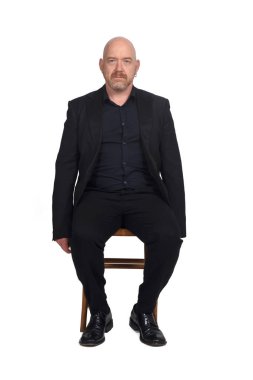 Beyaz arka planda sandalyede oturan bir adamın portresi.
