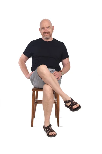 Beyaz Arka Planda Oturan Sandaletli Şortlu Kel Adam — Stok fotoğraf