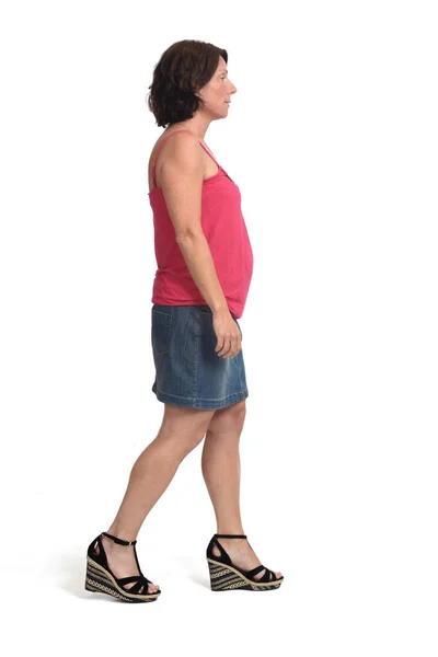 Beyaz Arka Planda Yürüyen Kot Etekli Bir Kadın — Stok fotoğraf