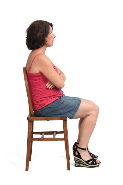 Boční Pohled Žena Sukni Sedí Bílém Pozadí Paže Zkřížené — Stock fotografie