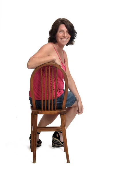 Žena Sukni Sedí Otočené Židli Dívá Kamery — Stock fotografie