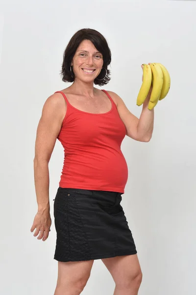 Donna Incinta Che Tiene Una Banana Sfondo Bianco — Foto Stock