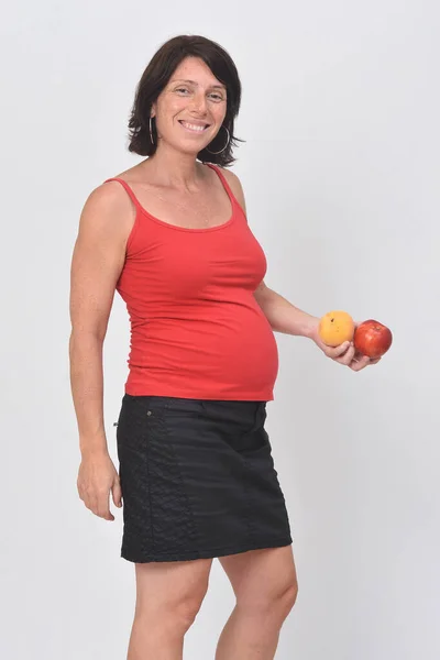 Έγκυος Γυναίκα Κρατώντας Ένα Δαμάσκηνο Λευκό Φόντο — Φωτογραφία Αρχείου