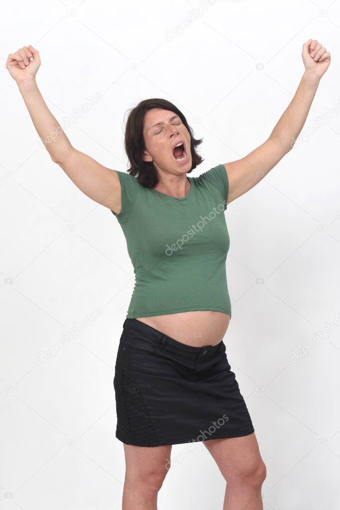 portrait of a pregnant woman with yawn and arms raised up on white background