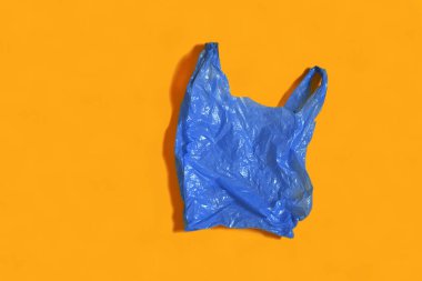 Turuncu arka planda mavi plastik çanta