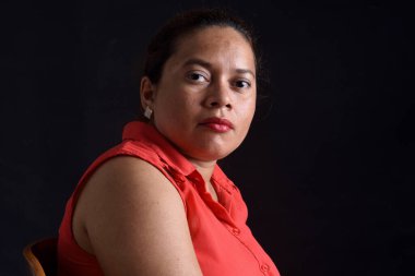 Siyah arka planda bir kadının portresi, ciddi.