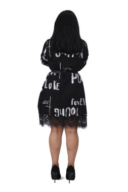 Beyaz arka planda yüksek topuklu ve elbiseli Latin bir kadının kolları çapraz.