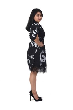 Beyaz arka planda yüksek topuklu ve elbiseli Latin bir kadının ön görüntüsü, elleri kalçasında.