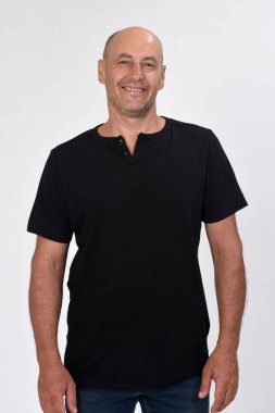 Beyaz arka planda tişörtlü bir adamın portresi.