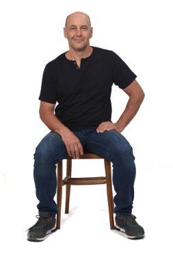 Beyaz arka planda oturan kel adam.,