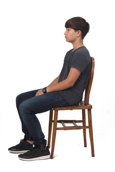 Genç Bir Çocuk Beyaz Arka Planda Bir Sandalyede Oturuyor — Stok fotoğraf
