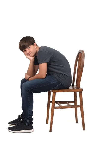 Έφηβος Αγόρι Κάθεται Και Σκύβει Μια Καρέκλα Λευκό Φόντο — Φωτογραφία Αρχείου