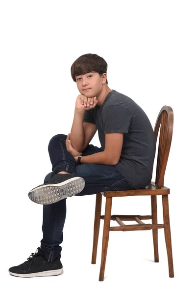 Nastolatek Chłopiec Siedzi Krześle Białym Tle Patrząc Aparat Fotograficzny Ręka — Zdjęcie stockowe