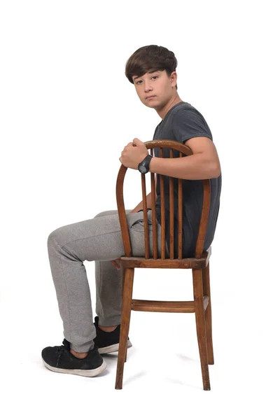 Vista Lateral Adolescente Sentado Uma Cadeira Com Fundo Branco Olhando — Fotografia de Stock