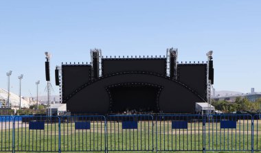 Stadyumun güvenlik bariyerlerinin arkasındaki boş konser sahnesi. Festivaller, kutlamalar ve konserler için bir mekan.