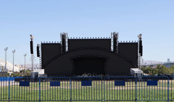 Stadyumun güvenlik bariyerlerinin arkasındaki boş konser sahnesi. Festivaller, kutlamalar ve konserler için bir mekan.