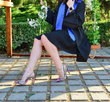 Kendinden emin öğrenci modelleri açık havada şık topuklu ayakkabılar ve seremoni sırasında zarif bacaklar giyerler.