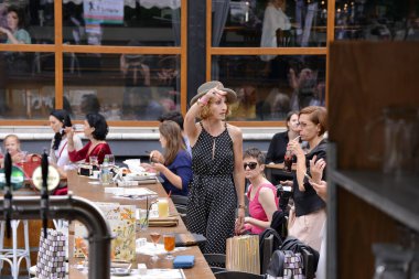 Timisoara, Romanya, 24 Haziran 2018, çanta ve gri şapkalı zarif kadın, yardım amaçlı opera fuarı başlamadan önce kuliste güven içinde poz veriyor.