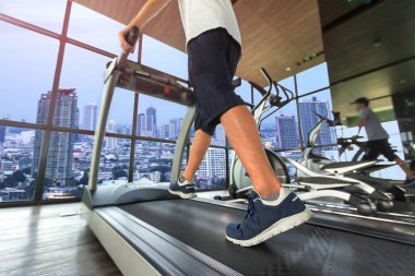 Alt beden spor giyim Paz ray ile fitness salonunda koşu bandı makinesinde çalışan genç adam bacak kısmında. Sıcak sesi. Sağlıklı ve egzersiz etkinlik kavramı. Egzersiz ve gücü eğitim Tema.