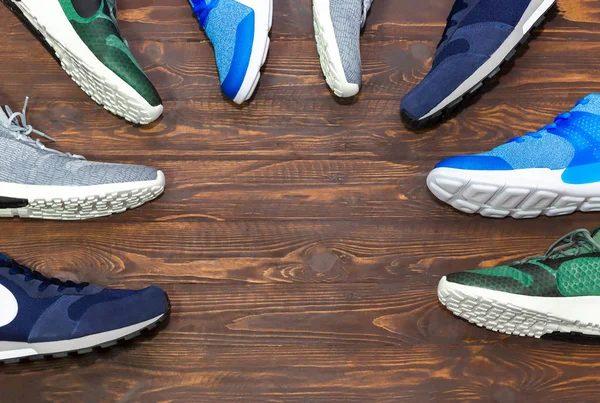 コピースペース付き木製の背景テクスチャ上の男性のための靴を実行しているブランドのない現代的な新しいスタイリッシュなスニーカーのトップビューショップ表示 — ストック写真