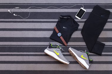 Bangkok, Tayland - 12 Ağustos 2018: Nike KAISHI 2.0 SE Run Shoes, DRI-FIT Cool Breeze, capri ürünü tam kadın pantolonu taytı, akıllı telefon uygulaması gri halı üzerinde izole edilmiş.