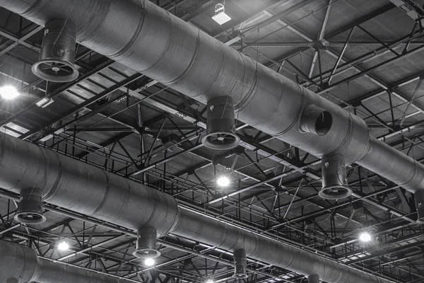 HVAC Duct Cleaning, Ventilation pipes in silver insulation material hanging from the ceiling inside new building.