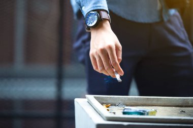 Adam el üzerinde sokak küllük, sigara izmariti, Sigara Sigara söndürme ölüyor. Sigarayı bıraktım. Sağlık kavramı. 