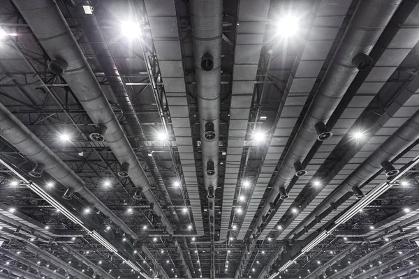 HVAC Duct Cleaning, Ventilation pipes in silver insulation material hanging from the ceiling inside new building.