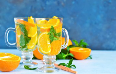 Soğuk yaz içeceği. Nane ve mavi bir arka plan üzerinde turuncu ile limonata.