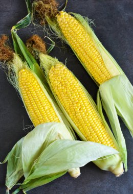 Siyah bir taş zemin üzerine taze, sulu, ham Mısır