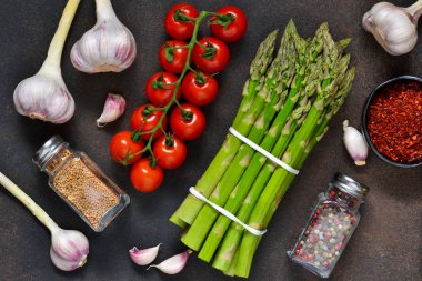 Yemek pişirmek için malzemeler. Taze sebze: kuşkonmaz, domates, sarımsak ve baharat. Organik gıda.
