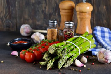 Yemek pişirmek için malzemeler. Taze sebze: kuşkonmaz, domates, sarımsak ve baharat. Organik gıda.