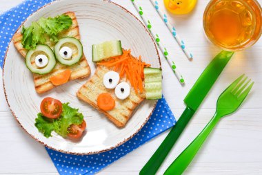 Bir çocuk - çocuk komik tost bir ızgara ile kahvaltıda ve havuç.