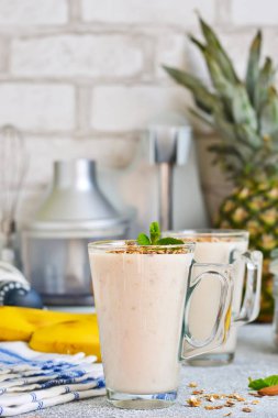 Yoğurt, ananas ve muz kahvaltı smoothies. 