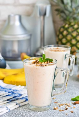 Yoğurt, ananas ve muz kahvaltı smoothies.