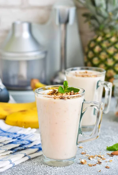 Yoğurt, ananas ve muz kahvaltı smoothies.