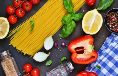 İtalyan yemeği arka plan. Makarna yemek pişirmek için malzemeler: spagetti, domates, fesleğen, karabiber karanlık bir beton zemin üzerine.