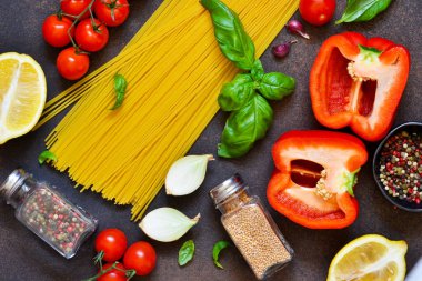 İtalyan yemeği arka plan. Makarna yemek pişirmek için malzemeler: spagetti, domates, fesleğen, karabiber karanlık bir beton zemin üzerine.