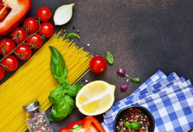 İtalyan yemeği arka plan. Makarna yemek pişirmek için malzemeler: spagetti, domates, fesleğen, karabiber karanlık bir beton zemin üzerine.
